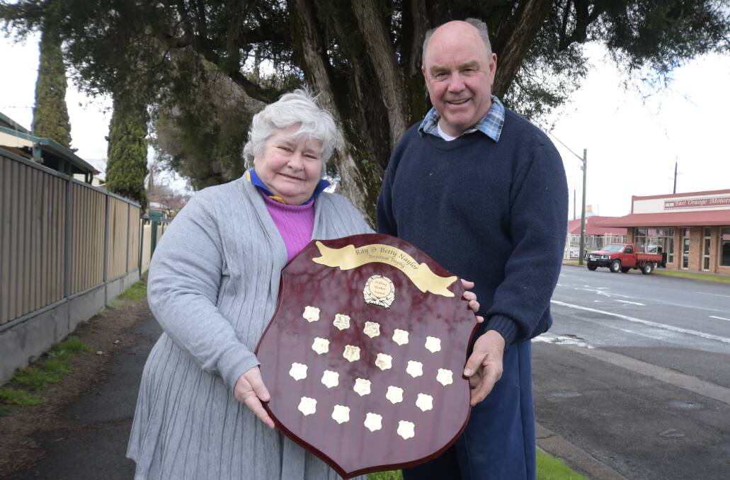 DELIGHTED: Sue Milne and show society president Peter Naylor with the Ray and Betty Naylor Perpetual Trophy for Willing Worker Award. Photo: JUDE KEOGH