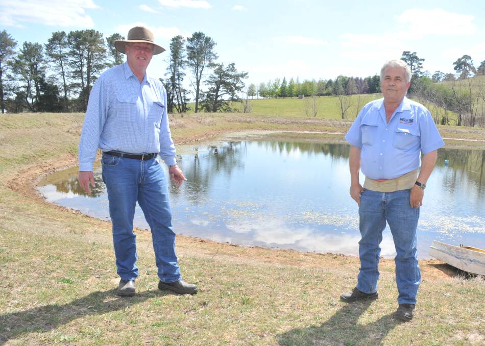 LOW LEVEL: NSW Farmers' Bruce Reynolds with grower Guy Gaeta at a dam on Mr Gaeta's Nashdale property. Photo: JUDE KEOGH 1004jkwater3