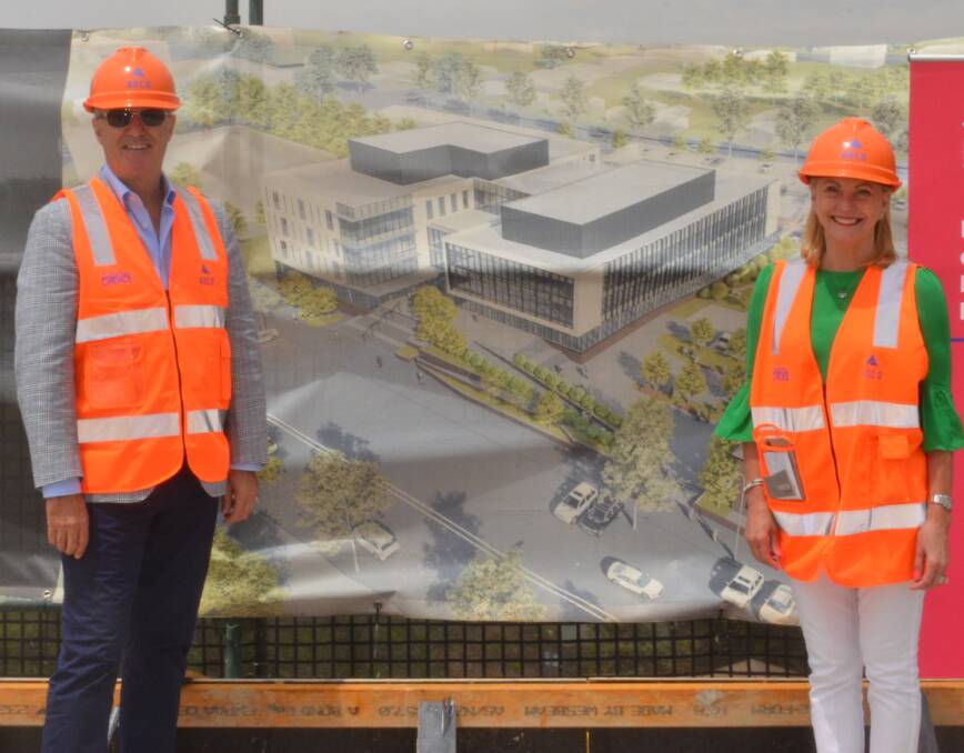 EXCITED: Developers Stephen and Jody Gosling with a banner showing the planned new building currently under construction. Photo: DAVID FITZSIMONS