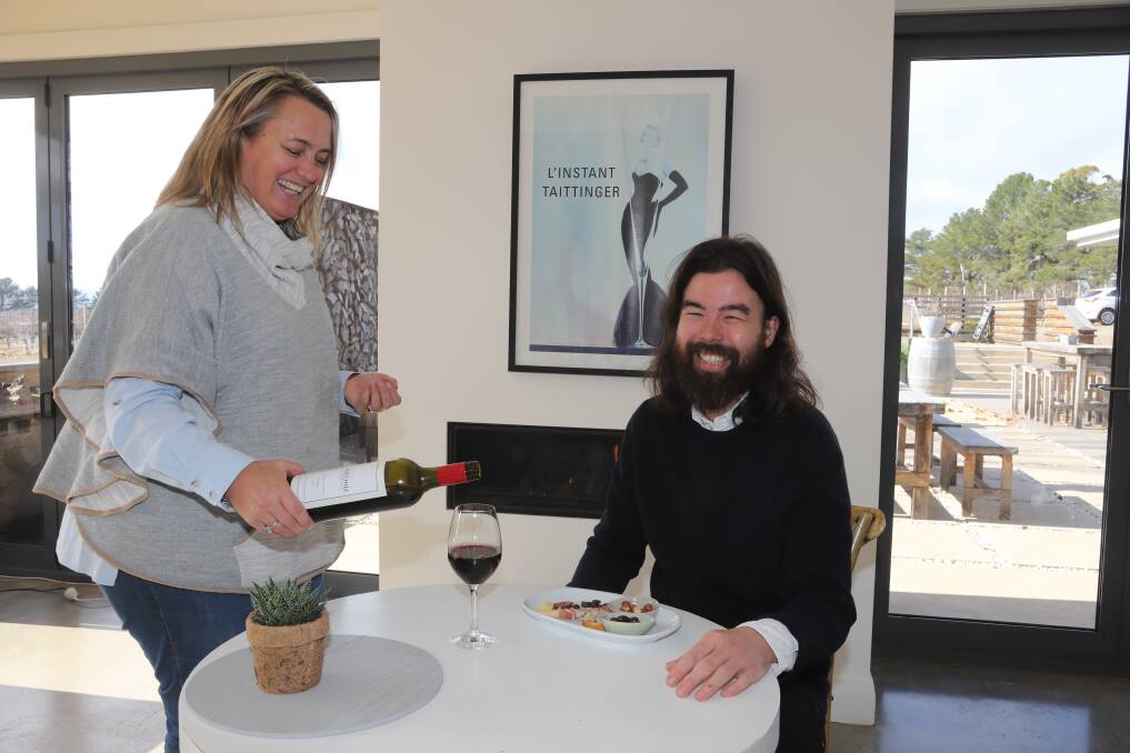 WINE AND CHEESE: Ross Hill Wines co-owner Chrissy Robson serves Shun Eto at the cellar door following the relaxation of COVID-19 rules. Photo: CARLA FREEDMAN