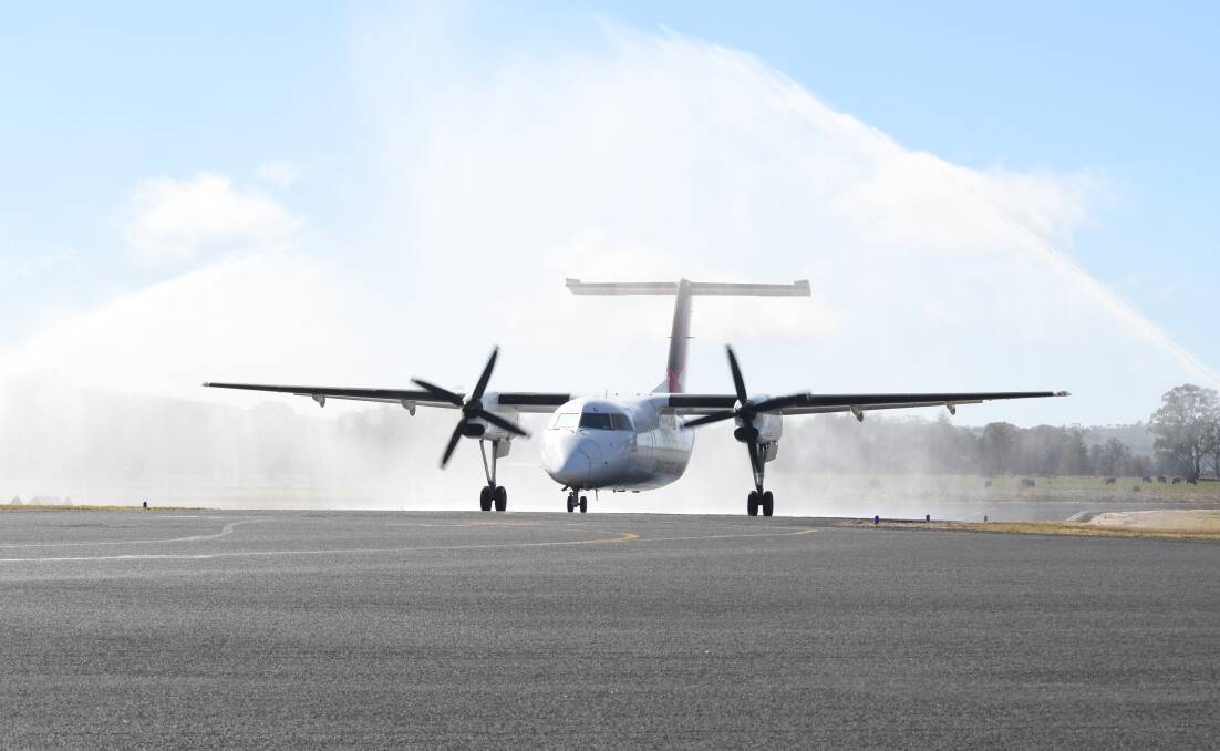 WET WELCOME: The QantasLink flight lands to a traditional water spray. Photo: CARLA FREEDMAN