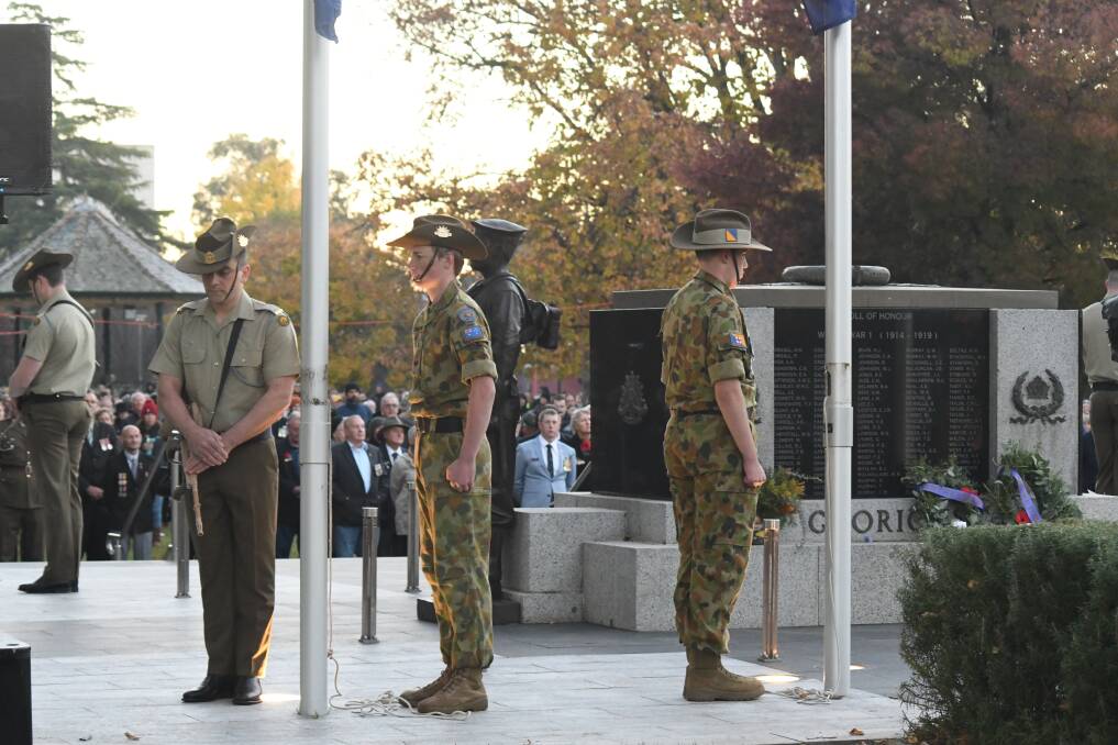 HISTORIC: The first sunlight of Anzac Day shines on formalities at the Dawn Service in Robertson Park on Sunday morning with a big crowd looking on. Photo: CARLA FREEDMAN