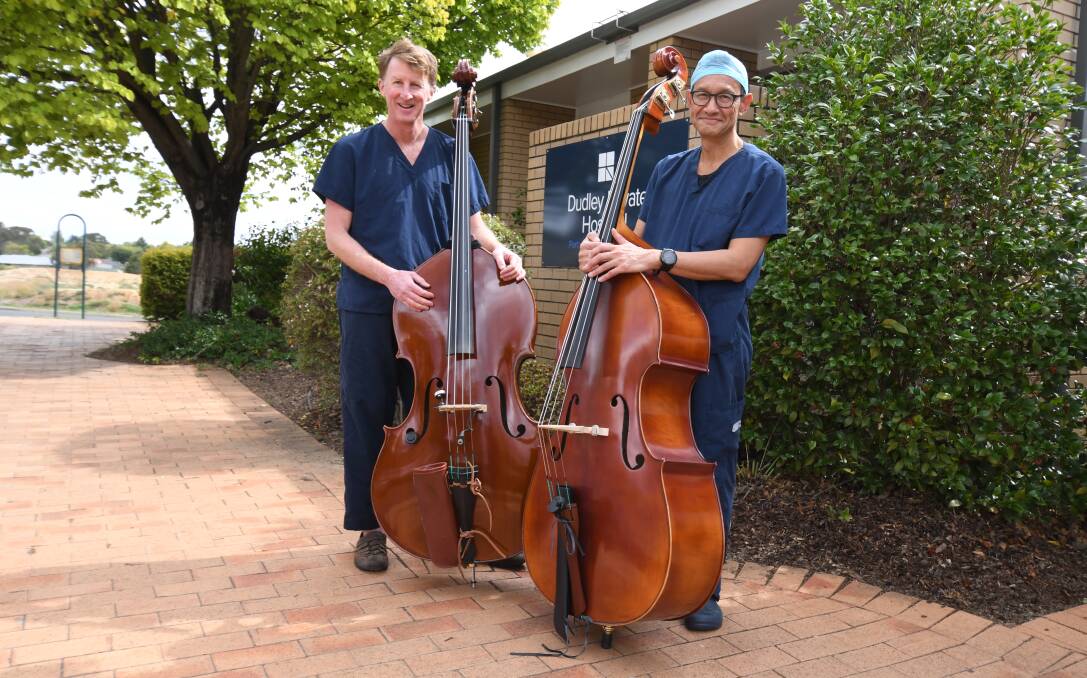 MUSICAL: Dr Ian Carter and Dr Sam Kwa play the double bass in the orchestra. Photo: JUDE KEOGH