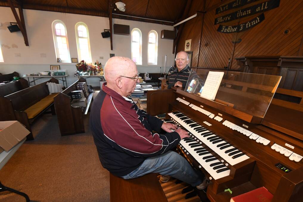 MAKING MUSIC: Richard Dutton plays the Five Ways church organ which is up for sale as part of the clearance as Ken Allen looks on. Photo: JUDE KEOGH 0509jkchurch1