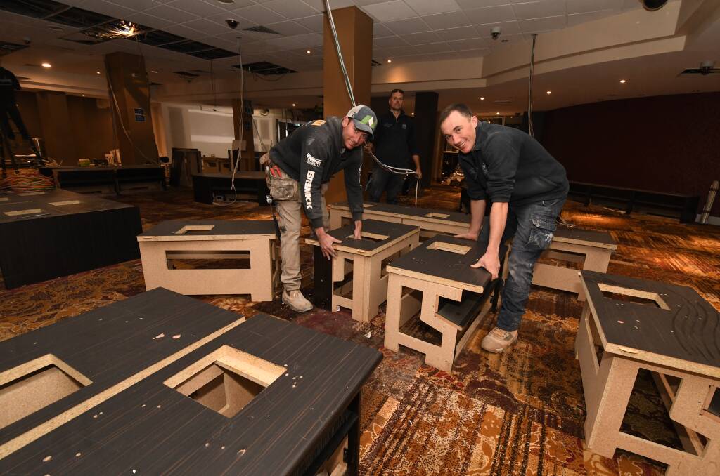 GAMING ROOM: Jason Hurford, Dean Vella and Will Parish move bases for poker machines inside the Orange Ex-Services' Club. Photo: JUDE KEOGH