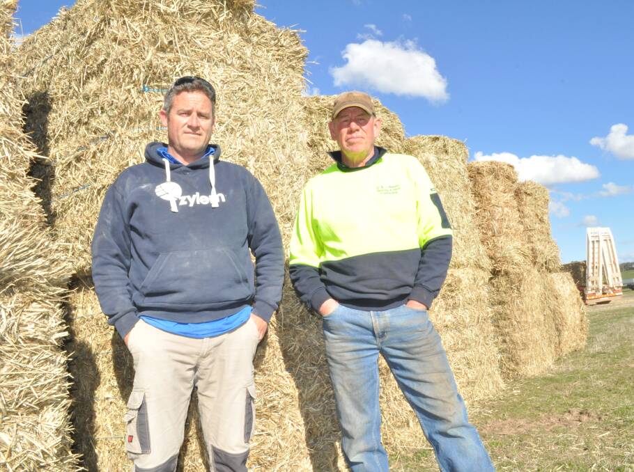 DROUGHT RELIEF: Farmer Matt Hannelly and truck driver Greg Waters at Borenore on Monday waiting to receive an allocation of the stack of hay. Photo: NICK McGRATH