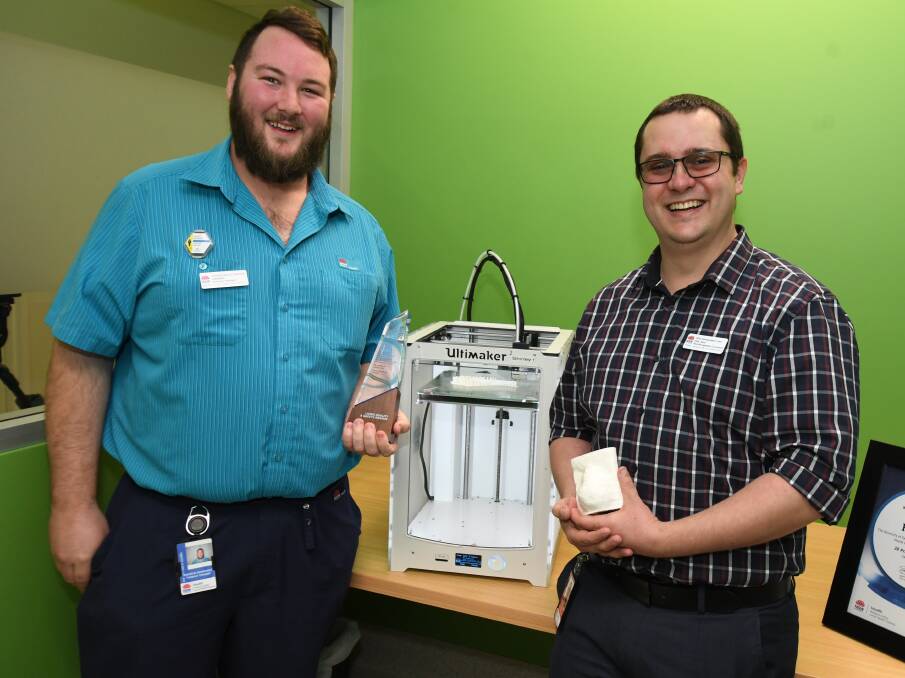AWARDED: Radiation therapists Andrew Skimmings and Philip Kent with Shirley the 3D printer and their award. Photo: JUDE KEOGH 0710jkprint4