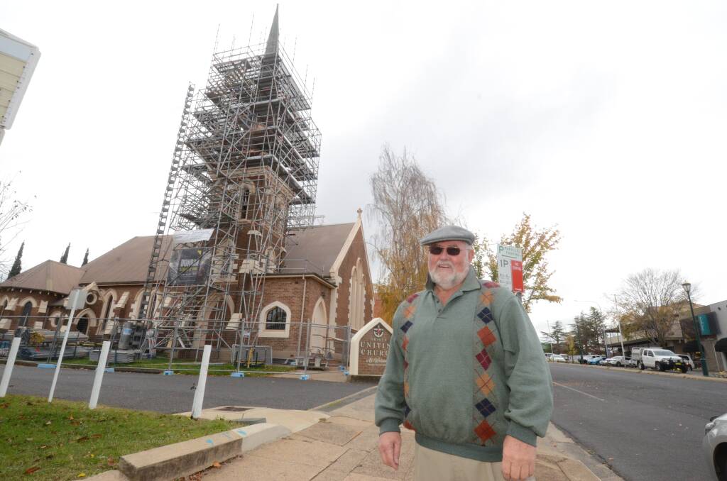WORK UNDERWAY: Wesley Uniting Church official Bob Nash with the church spire clad in scaffolding. Photo: JUDE KEOGH
