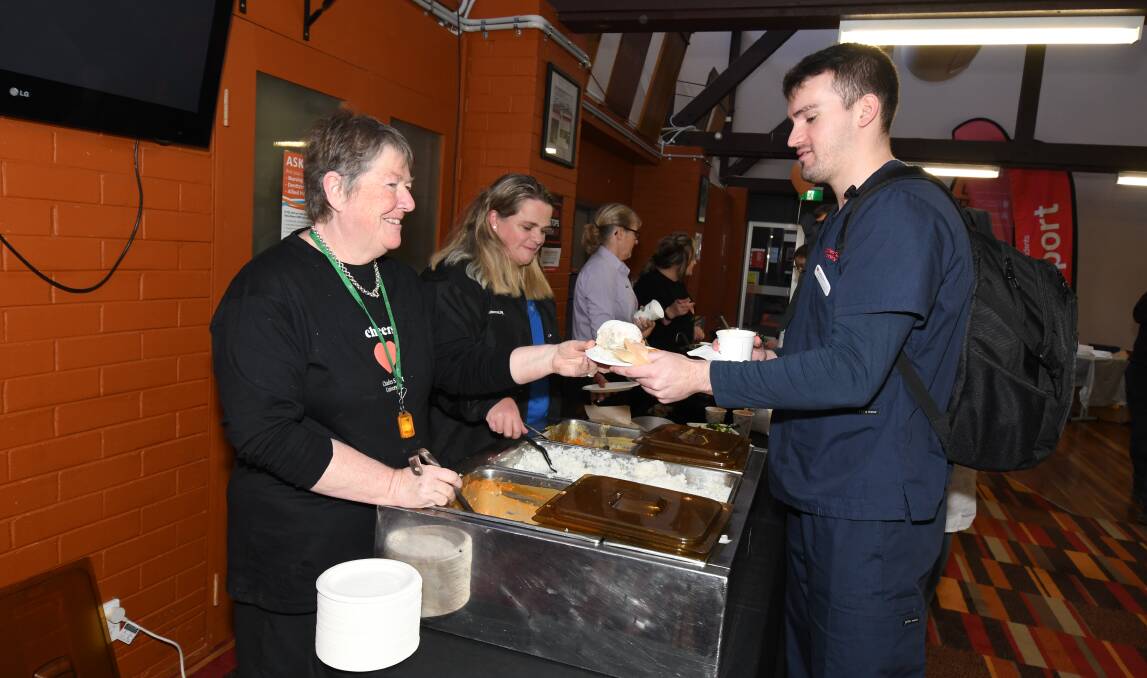 LUNCH: Jan Storey and Terri-Lee Duffy, who were serving food, with Harrison McCarthy. Photo: JUDE KEOGH 0717jkcsu8