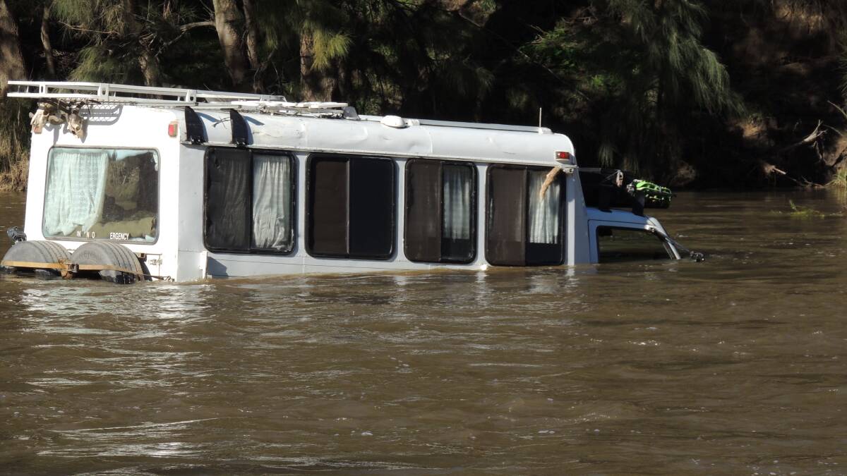 FLOODED: The camper van caught in the Macquarie River after apparently being swept off the causeway. Photo: Supplied