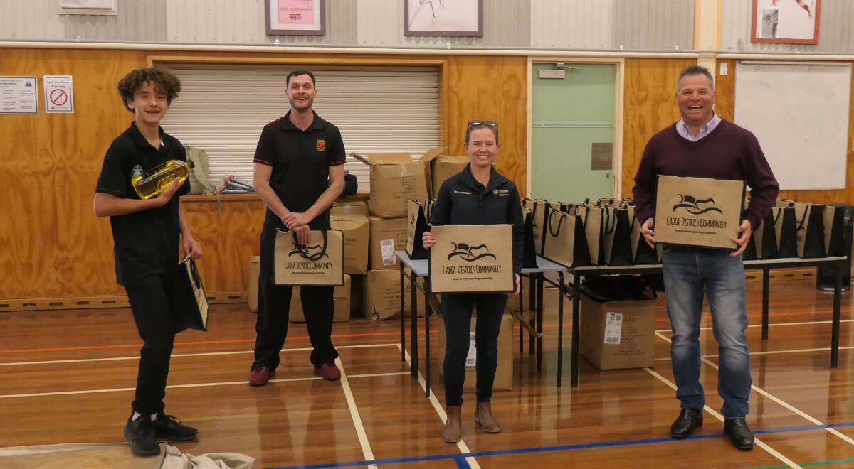 HELPING OUT: Clontarf's Isaiah King and Austen Logan, Cadia's Teiya Thornberry and Phil Donato chip in to pack the hampers. Photo: Supplied