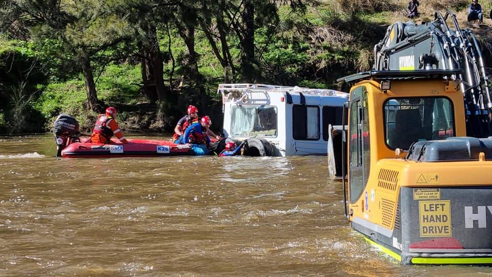 RESCUE: SES crews work in the river to attach the motorhome to the excavator. Photo: Supplied