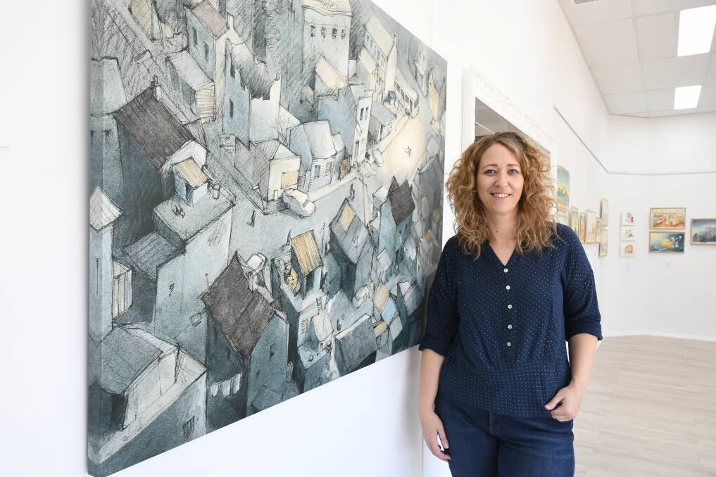 MAJOR WORKS: Leiarna Dunworth, director of The Peisley Street Gallery, with some of Freya Blackwood's illustrations on show at the gallery. Photo: JUDE KEOGH 0123jkfreya1