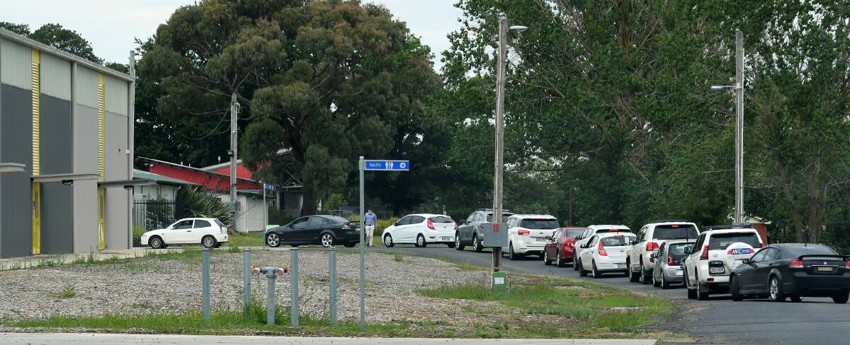 MAKING SURE: People wait in a queue of cars on Monday for COVID-19 tests at the Orange Showground's Naylor Pavilion. Photo: CARLA FREEDMAN