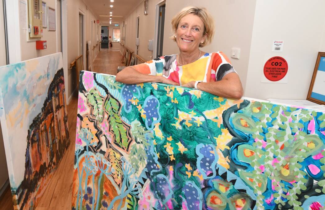 VIBRANT: Kezz Brett with an artwork she is donating to Orange's new palliative care unit at Uniting Parkwood. Photo: JUDE KEOGH 0321jkpalliative3