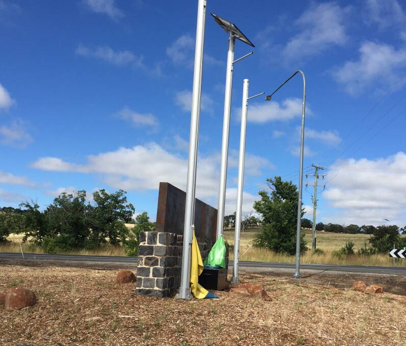 DAMAGED: The flags lie behind the structure at Orange's new welcome sign on the Mitchell Highway.