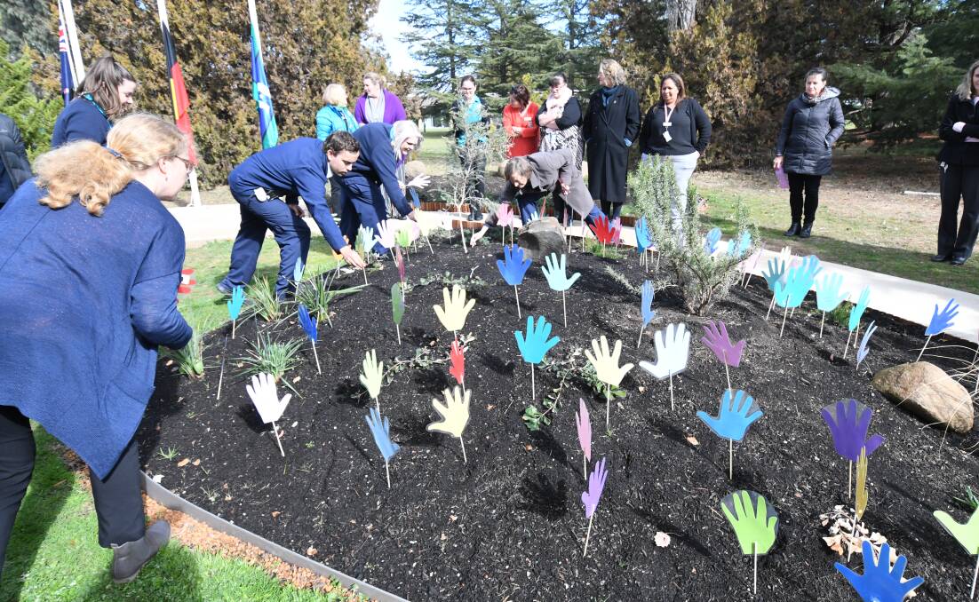 PLANTING DAY: Staff place the hands in the Aboriginal Gathering Space garden at the rear of Orange hospital as part of National Reconciliation Week. Photo: JUDE KEOGH 0530jkrecon3