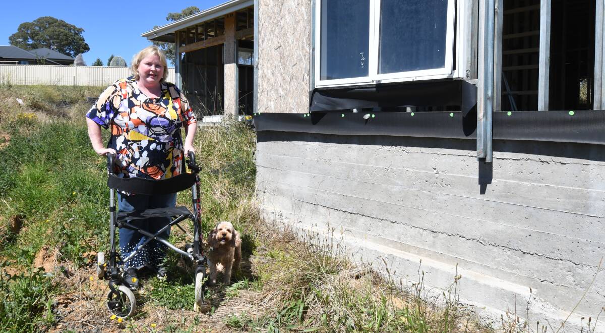HOPEFUL: Fiona Bond and Daisy outside her unfinished home in north Orange as she awaits building work to start later this month. Photo: CARLA FREEDMAN