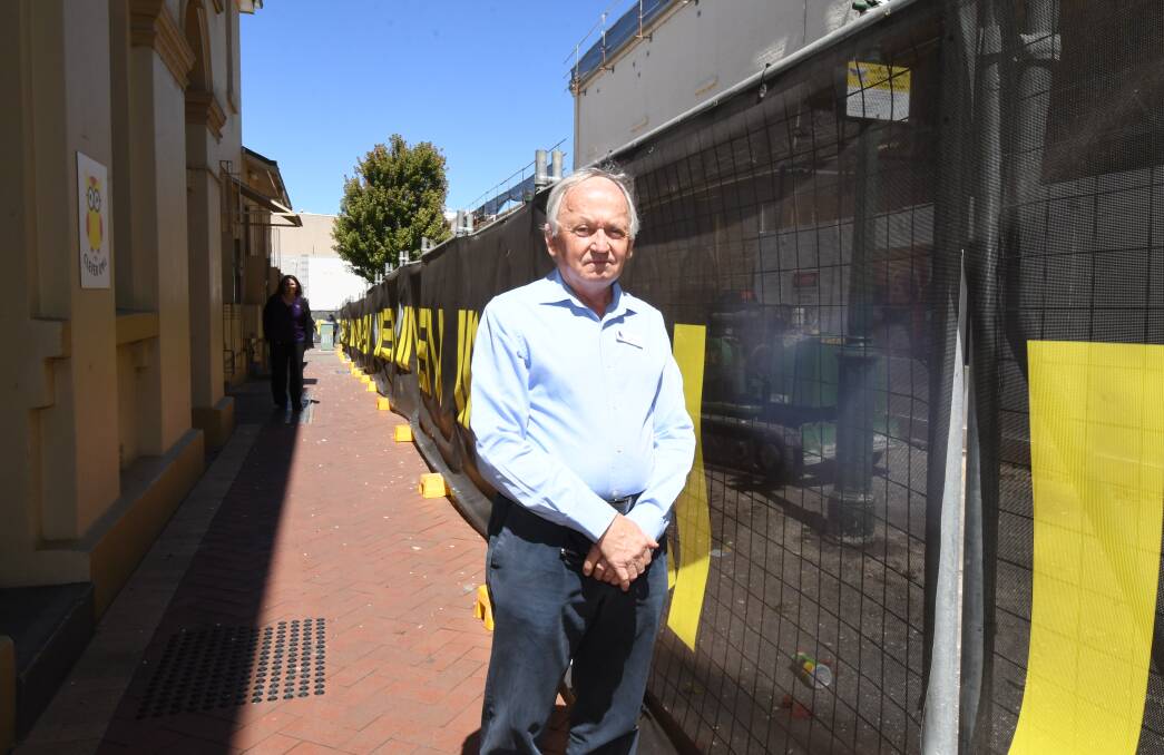 UPSET: Businessman Phillip Schwebel in Post Office Lane with the development work site and the remaining tree in the background. Photo: CARLA FREEDMAN 