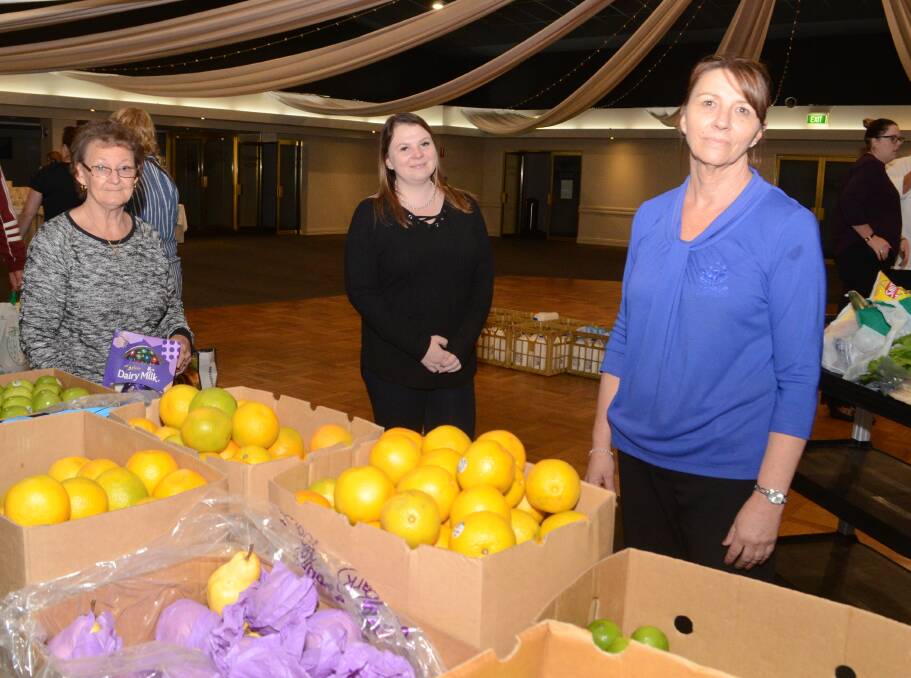 FOOD FOR ALL: Yvonne Hughes, Taylor Jones and Jo Clifford with boxes of fresh food at the Ex-Services' Club on Wednesday. Photo: JUDE KEOGH