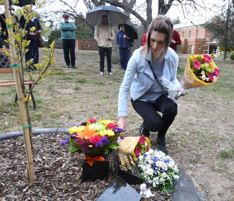 FOR HOPE: Tanya Wilcox places flowers at the Hope's Garden memorial resting place for babies. Photo: JUDE KEOGH 1008jkhope1
