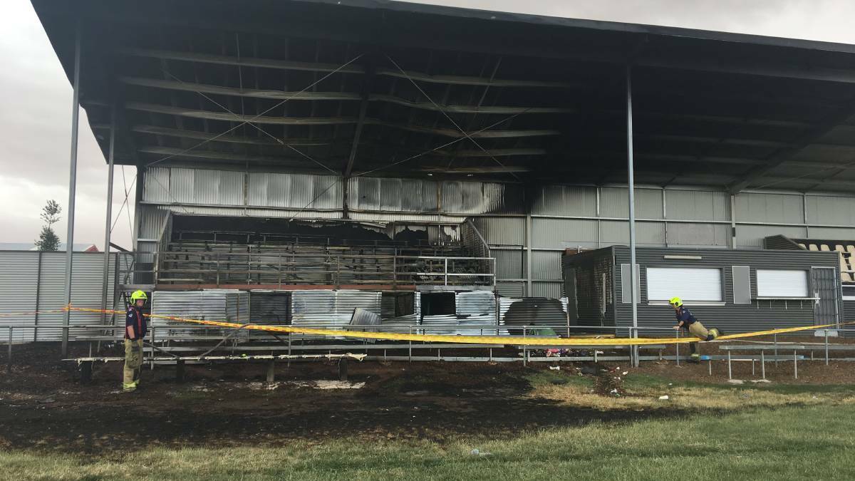 ONE YEAR AGO: Firefighters examine the scene after fire damaged the grandstand on November 30 last year.