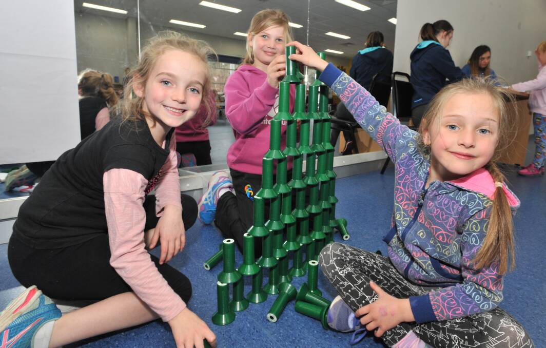 CREATIVE: Ava Elmes, Annabelle Tink and Evelyn Marr build a tower at PCYC during the last school holidays. Photo: JUDE KEOGH
