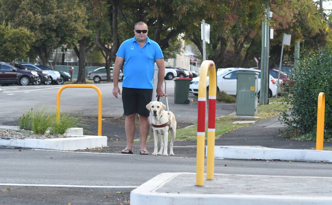 ON THE LEVEL: Matthew Goodacre, at the March Street and Lords Place intersection with his guide dog, is concerned about safety for people with visual impairments. Photo: JUDE KEOGH 0405jkcross1