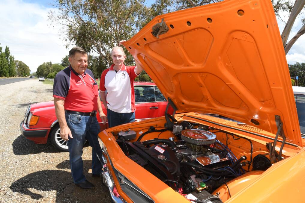 UNDER THE BONNET: Allan Goodacre and Rob Gazzard look under the hood of Rob's 1972 Holden Kingswood. Photo: JUDE KEOGH