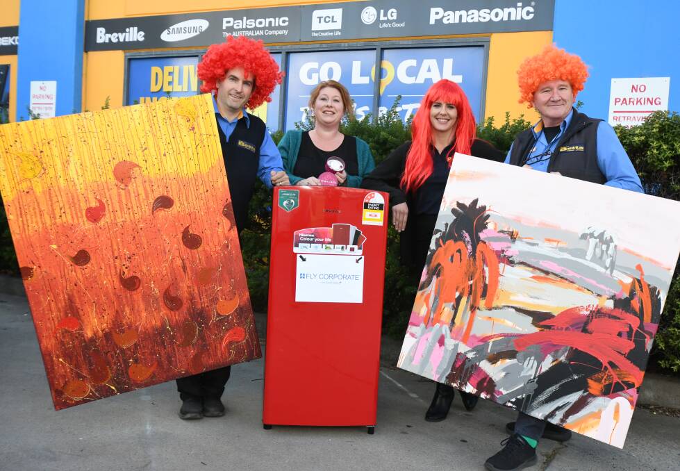 GINGER PRIDE: Drew Weily, Rachael Brooking, Clare Smith and Garry Ozols with paintings and prizes up for auction at Saturday's festival. Photo: JUDE KEOGH 0925jkredhead