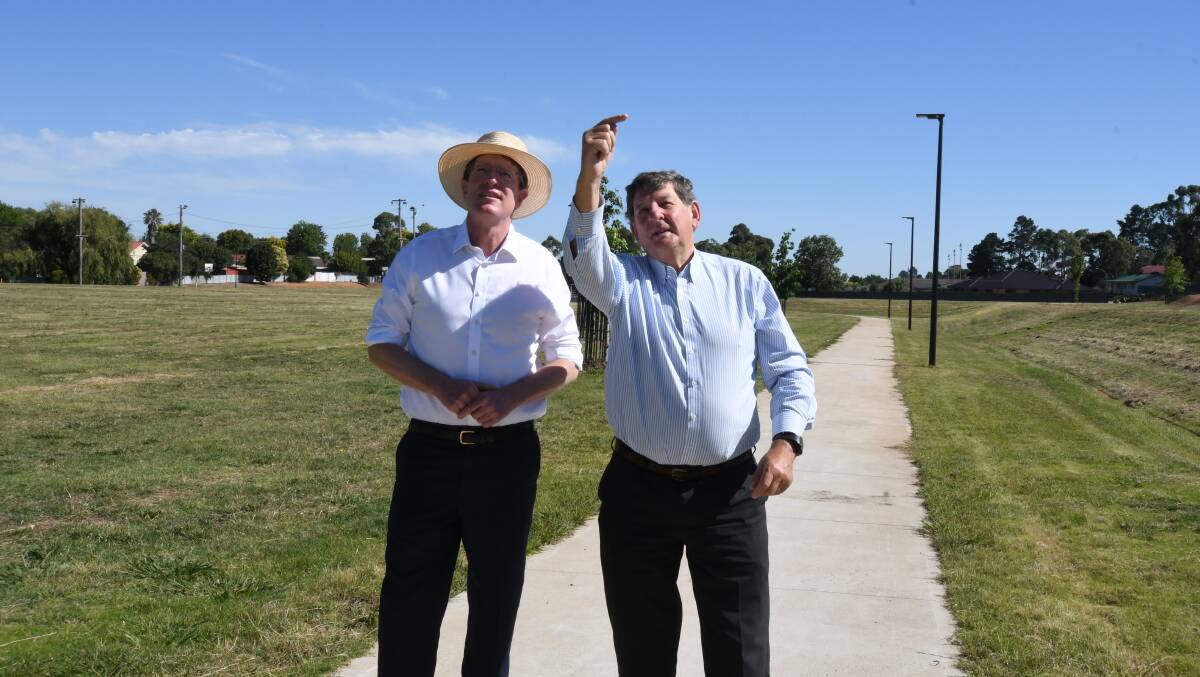 LIGHTS ON: Member for Calare Andrew Gee and Orange mayor Reg Kidd look at the new lights installed at Glenroi Oval as part of a safety upgrade. Photo: JUDE KEOGH