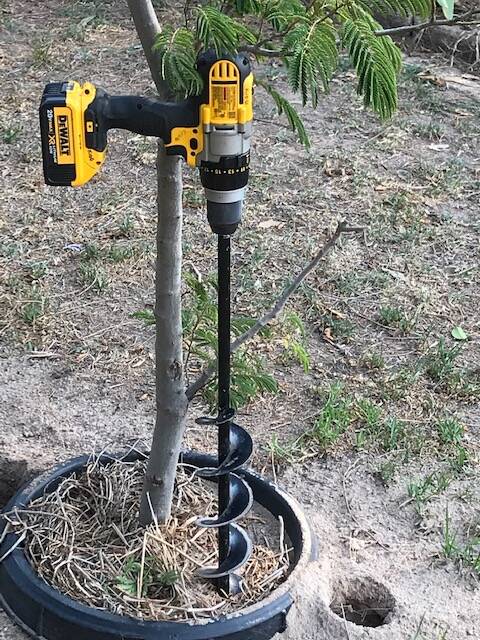 DRILL: Use an auger or one as a drill attachment to create watering holes to reach the root zones of your trees and plants.