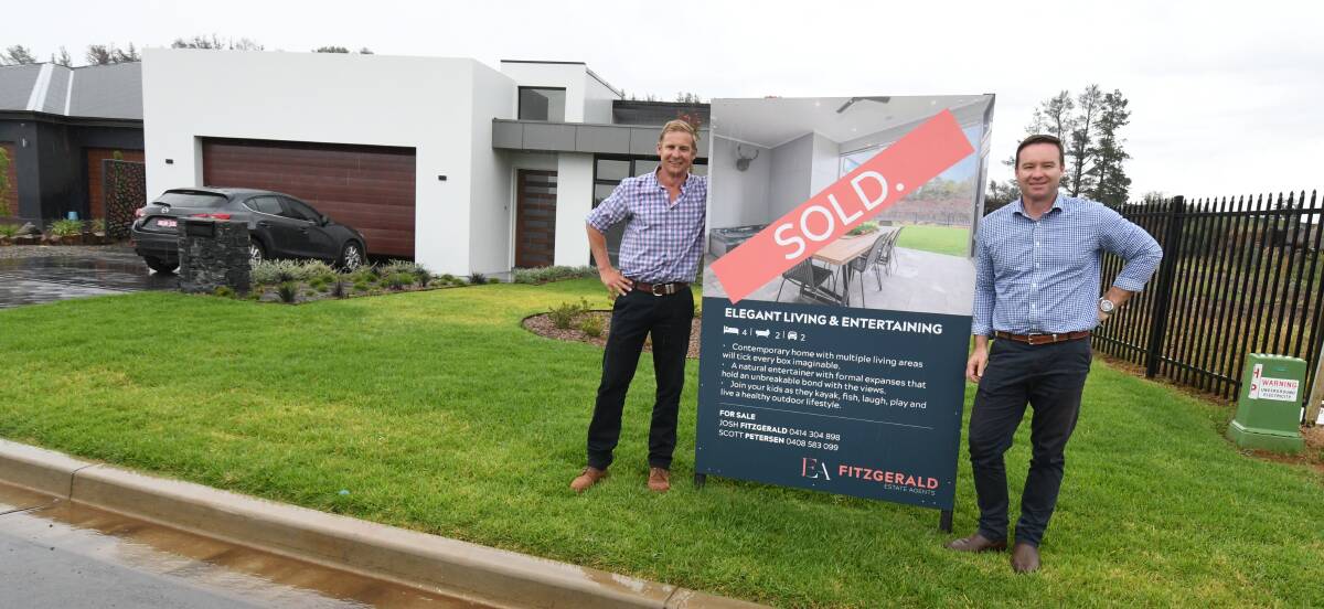 FIRST SALE: Scott Petersen and Josh Fitzgerald from Fitzgerald Estate Agents outside the Bluestone Lake home. Photo: JUDE KEOGH