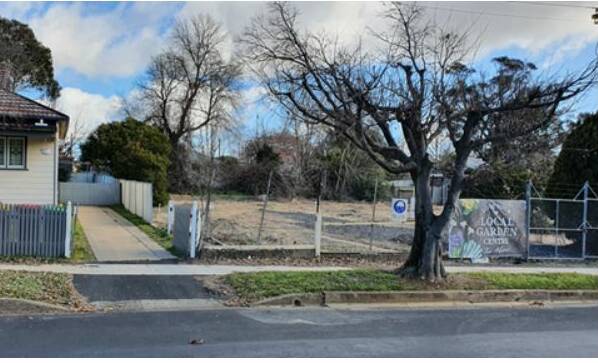 DRIVEWAY SITE: The Taco Bell entrance is proposed to be sited where the tree is in this council photo and run alongside the fence next to the residence.