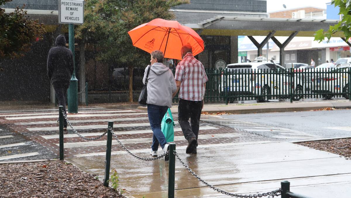 KEEPING DRY: Shoppers in the wet on Monday morning. Photo: CARLA FREEDMAN
