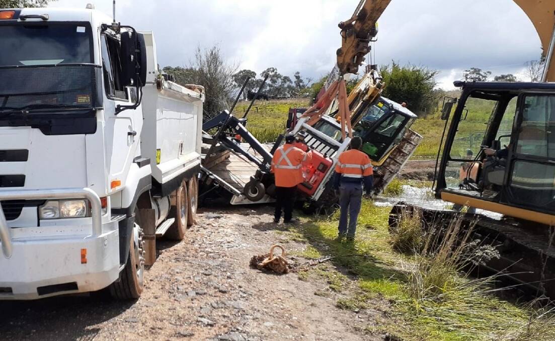 BIG WET: Crews work to clear the vehicle's trailer after the road edge gave way. Photo: Supplied