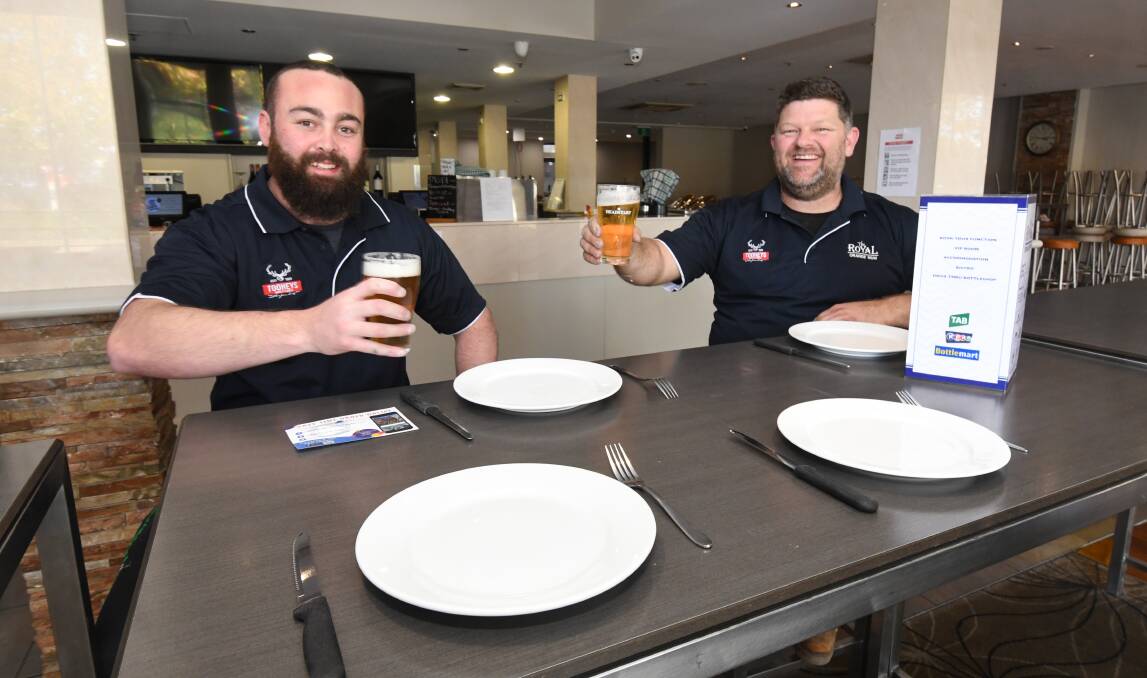 CHEERS: Royal Hotel's James Angus and manager Adam Isbester keep their distance at the hotel which is to allow some in-house dining. Photo: JUDE KEOGH