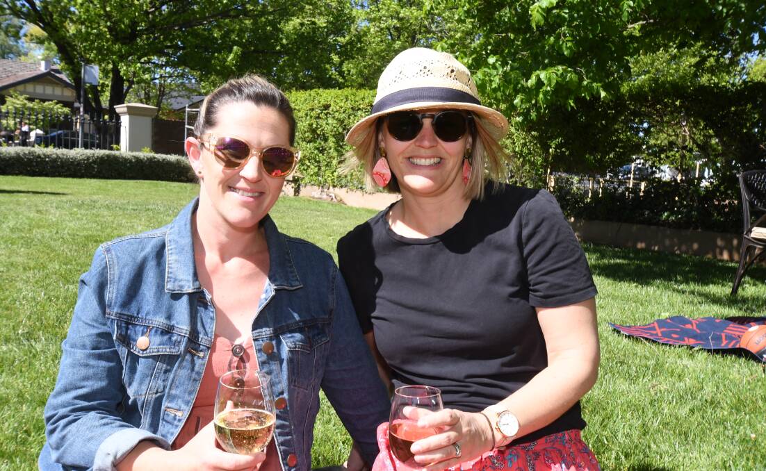 WINDING DOWN: Lyndall Omrod and Hannah Short relax at a Wine Festival final day event on the lawns at Zona on Summer Street. Photo: CARLA FREEDMAN