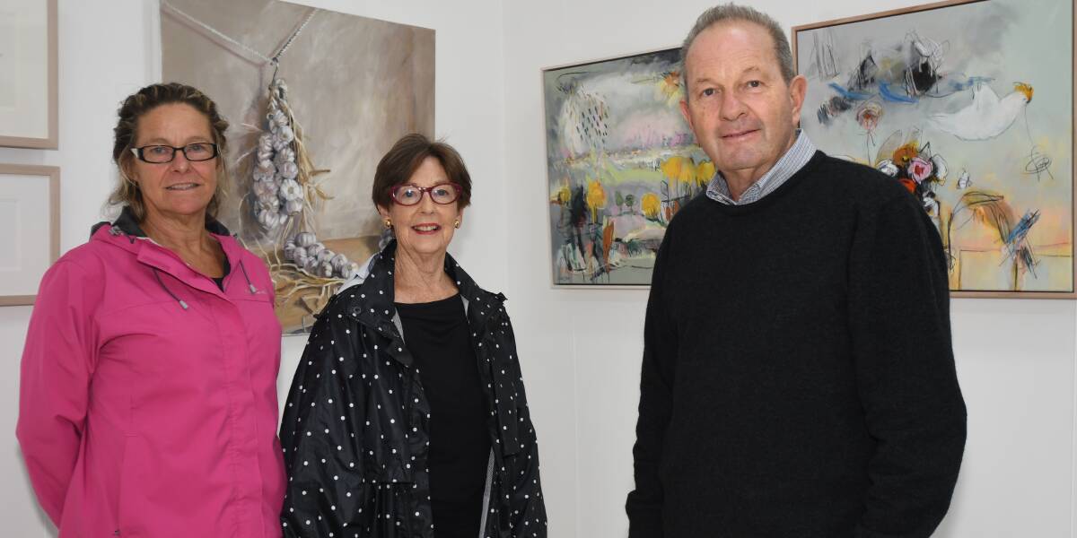 ARTISTS: Jo Sangster, Loretta Blake and Andrew Jaffray at the gallery in front of works by Stuart Whitelaw (left) and Mrs Blake. Photo: CARLA FREEDMAN 0325cfharvest3