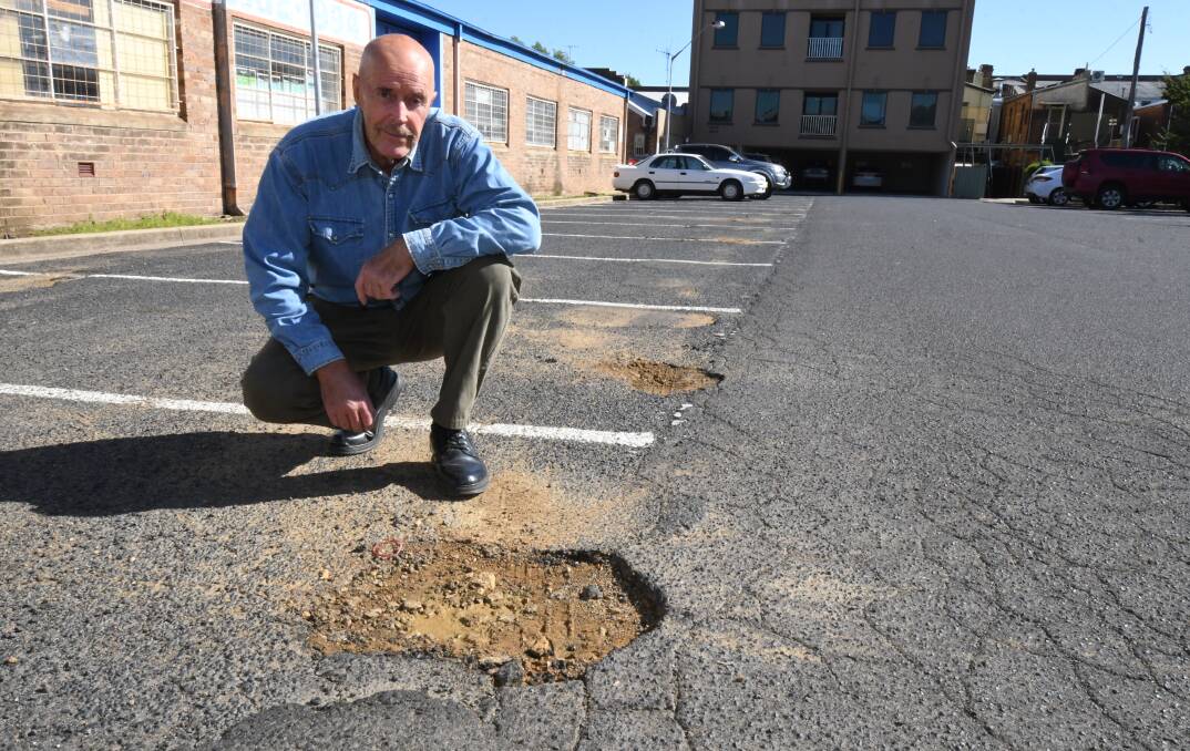POTHOLES: Steven Anderson in the car park off Peisley Street where he says potholes and damage need repairing. Photo: JUDE KEOGH