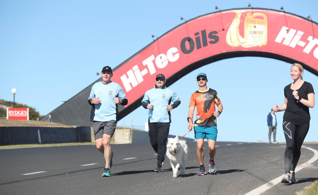 CONQUERING THE MOUNTAIN: Orange-based police officer Phil Mounce-Stephens (left) and his support runners complete another circuit of Mount Panorama during his 24-hour effort in the name of Police Legacy.