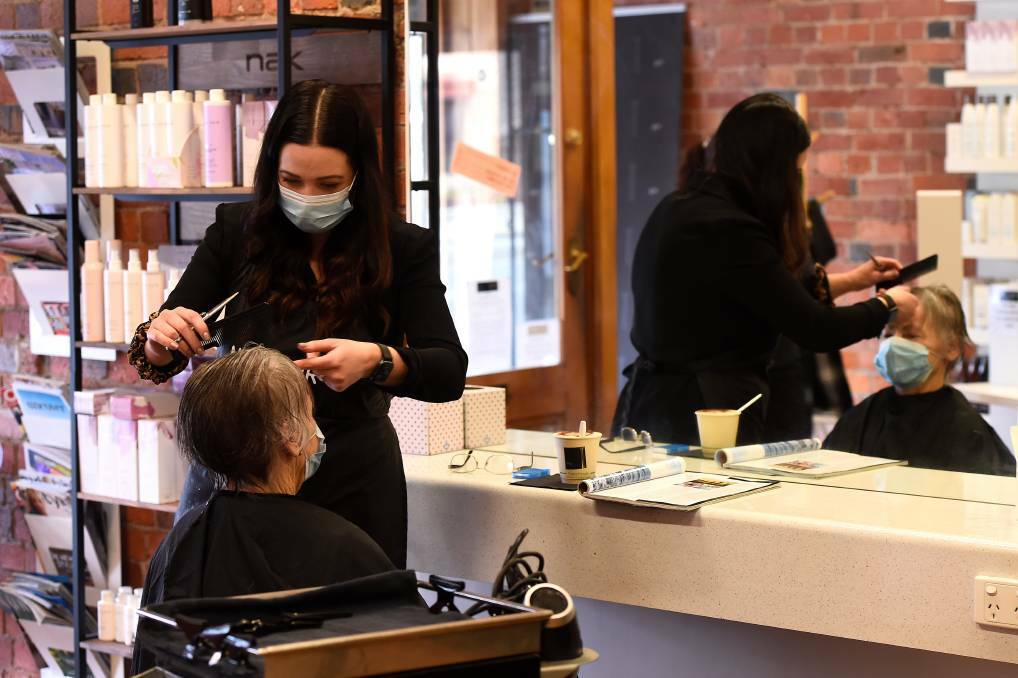 IS THIS THE FUTURE: Masks are to be compulsory in public in Victoria. Ballarat hairdresser Aleesa Campbell and a client say they feel more comfortable 'masking up' . Photo: ADAM TRAFFORD
