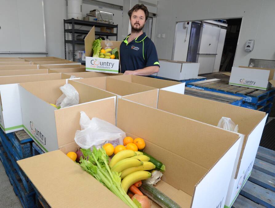 STRATEGY CHANGE: Clint Evans prepares Country Fruit Distributors fruit and vegetable boxes for delivery across Orange. Photo: JUDE KEOGH