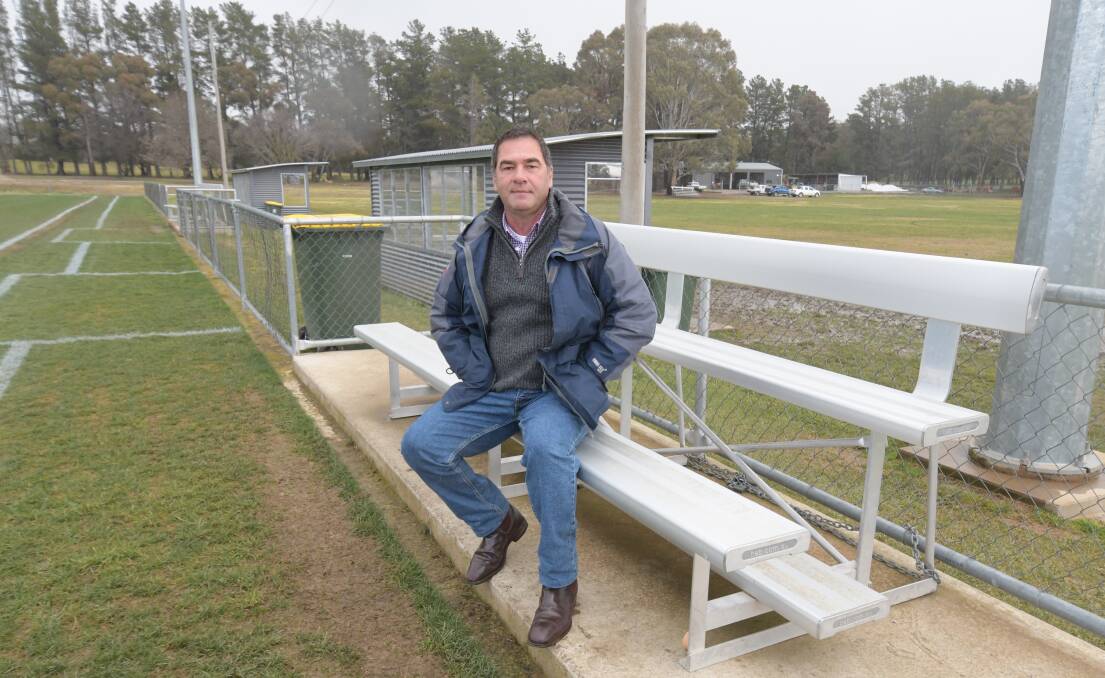 BENCH: ODFA president Tony Mileto on one of the un-sheltered reserves benches at Bernie Stedman Field. Photo: JUDE KEOGH