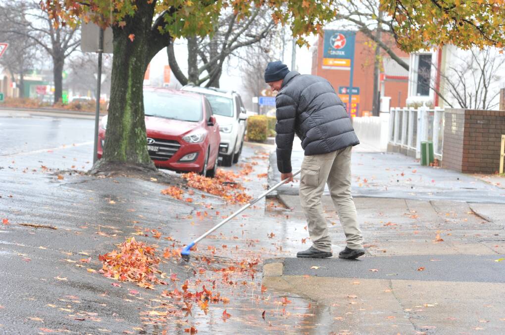 JUNE 2021: Roger Annis-Brown clears leaves in Summer Street on Thursday. Photo: JUDE KEOGH