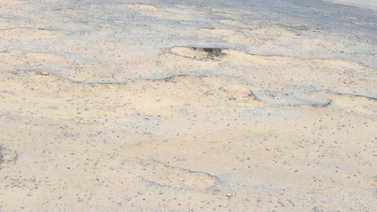 BREAKING UP: Potholes on Scott Place. Photo: JUDE KEOGH
