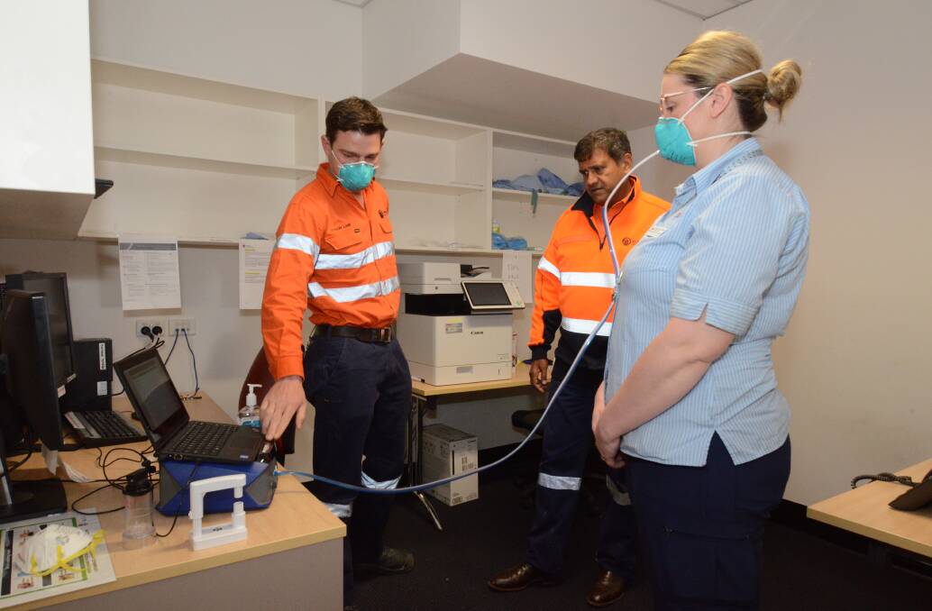 SAFETY: Cadia's Tyson Lane shows CEO Sandeep Biswas and infection prevention and control clinical nurse Alannah Britt the machine in operation. Photo: JUDE KEOGH