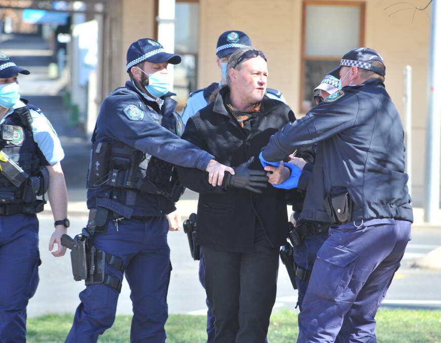 PROTEST MEETING: A man not wearing a mask is arrested by police outside the Orange City Council building in Byng Street on Tuesday morning. Photo: JUDE KEOGH