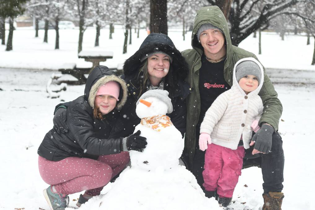 SNOW FUN: Lilly O'Donnell, Kandii Fuller, Dave and Magnolia O'Donnell make a snowman in Elephant Park on Thursday. Photo: JUDE KEOGH