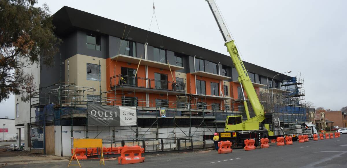 SCAFFOLDING DOWN: Workers reveal the front of the Quest Apartments building on Kite Street on Monday morning. 